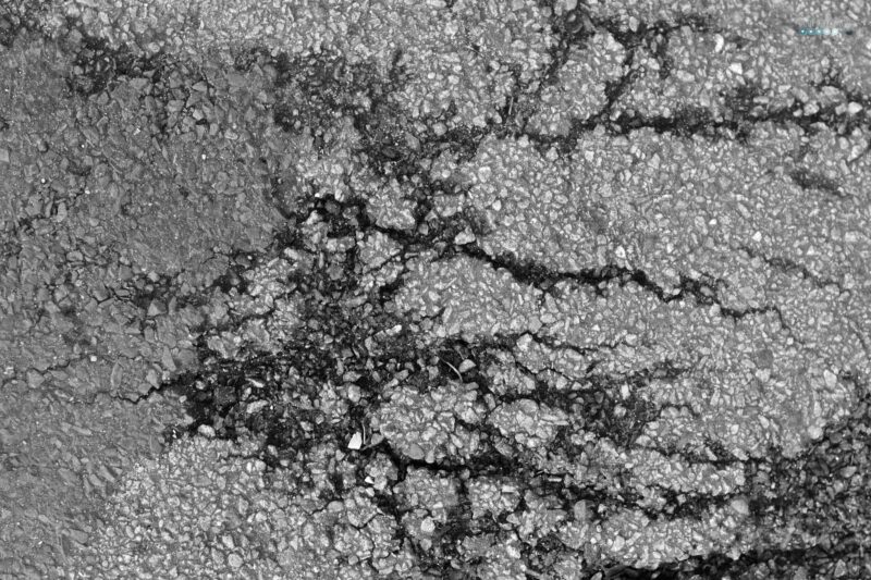 shattered dreams black asphalt with cracks
