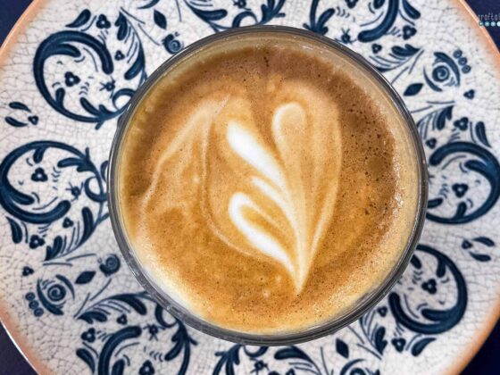 cup of coffee with heart of foam in blue pattern plate