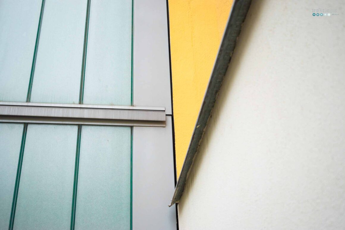 a detailed shot of a building that forms an artistic view with its colored areas the main one being a yellow triangle