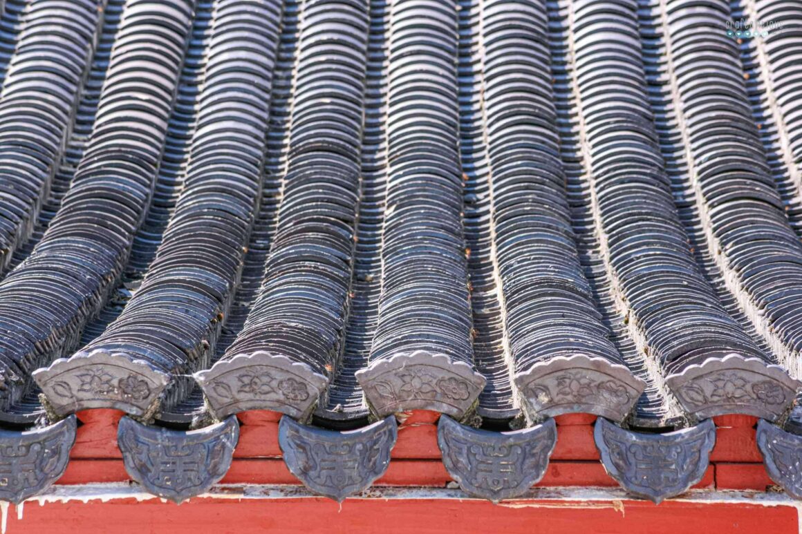 a row of gray tiles on a red wooden roof – Chinese style
