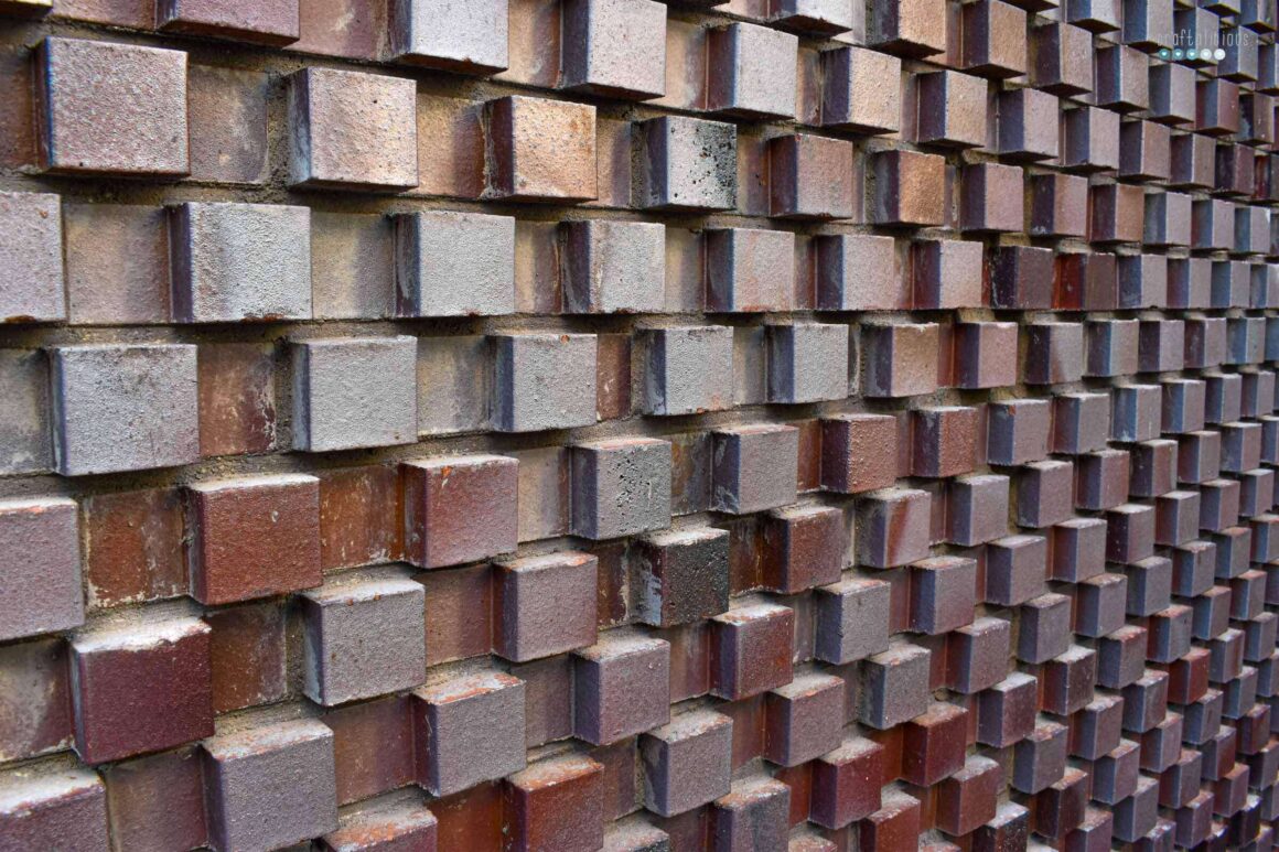 a brick wall from which squares are studding out creating a pattern